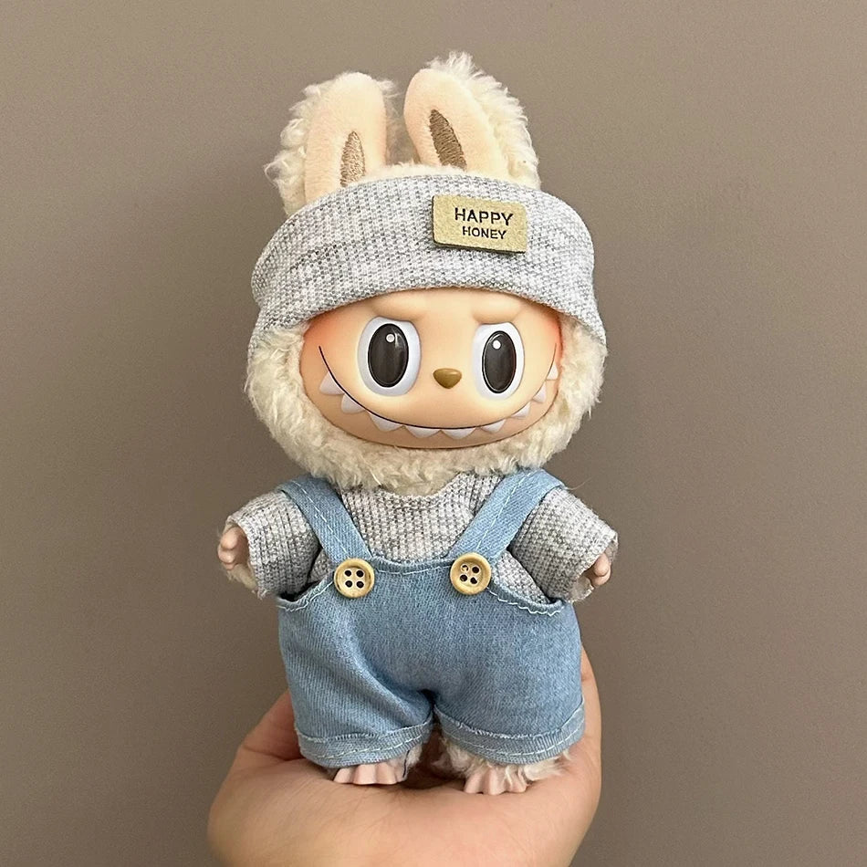 Labubu wearing a Happy Honey outfit with denim overalls, a gray sweater, and a knit beanie.