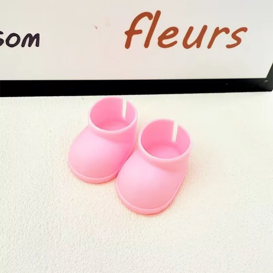 A pair of plain light pink miniature chunky boots for a Labubu figure, with a smooth texture and thick soles, sitting on a white surface.