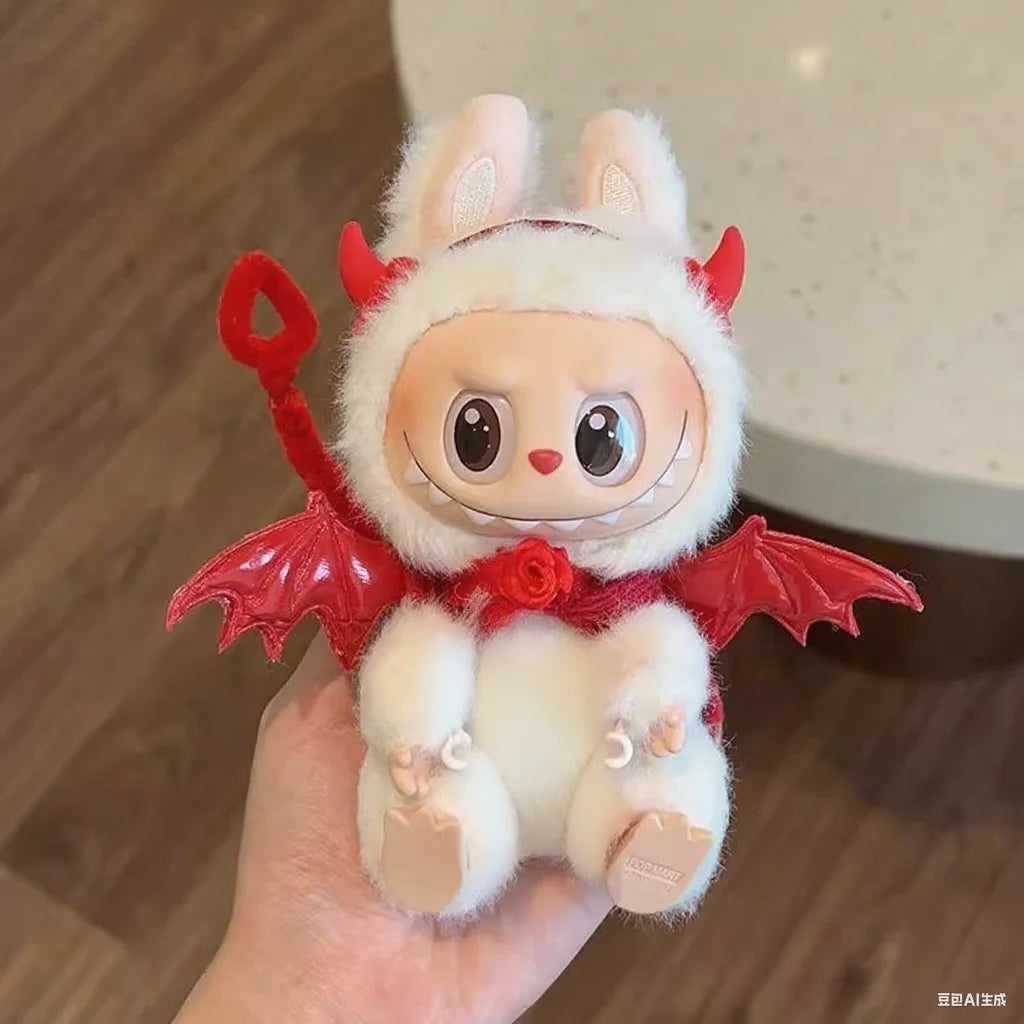 A Labubu figure wearing a fluffy white devil outfit with red horns, wings, and a tail, held in a person's hand.

