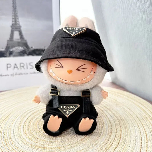 Labubu wearing a black 'PPADA' fashion outfit with an overall, a shirt, and a bucket hat.

