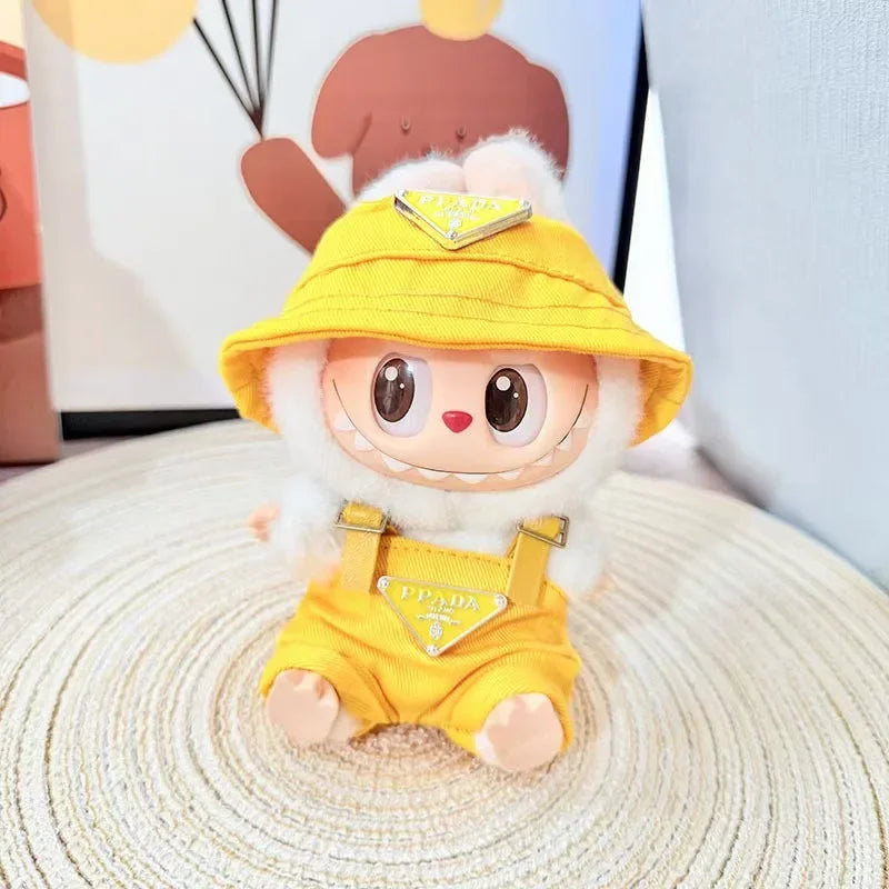 Labubu wearing a yellow 'PPADA' fashion outfit with an overall, a shirt, and a bucket hat.
