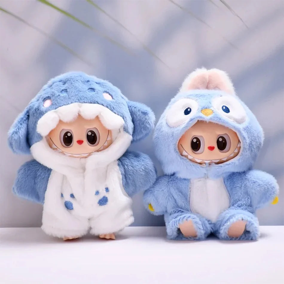 Two Labubu figures in fluffy blue animal bodysuits. One on the left is a shark with paw prints, and the one on the right is a bird with a yellow beak. The figures are standing side-by-side against a blue and white background.

