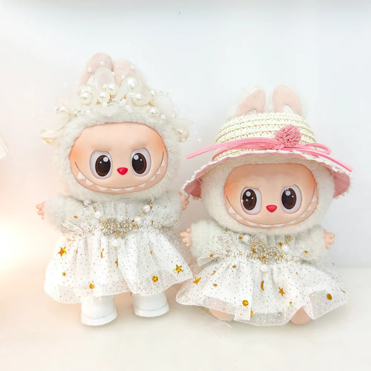 Two Labubu figures in matching white star princess dresses, one with a crown and one with a straw hat.